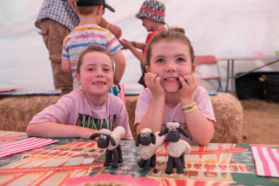 two children posing with their shaun the sheep creations they made at the festival