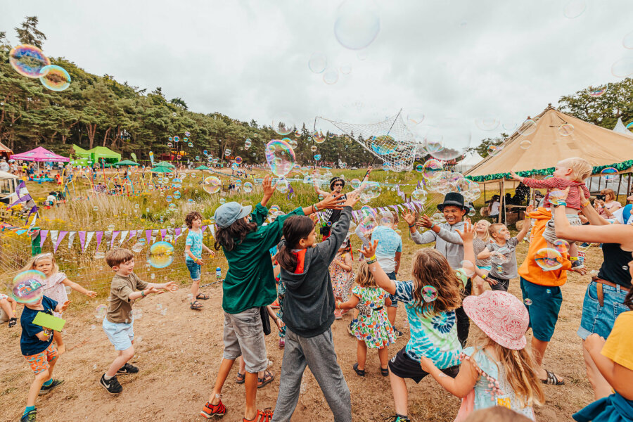 a group of children playing and catching bubbles