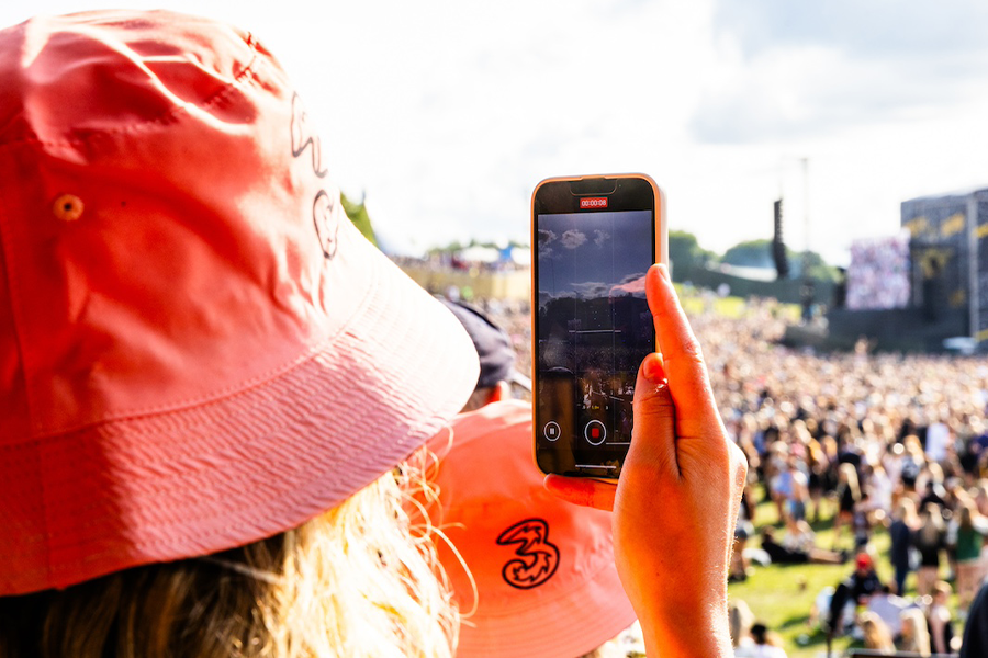 person holding a phone, they're wearing a pink bucket hat