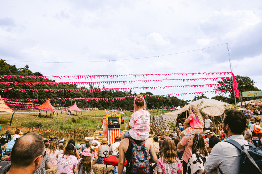 a crowd watching punch and judy at latitude